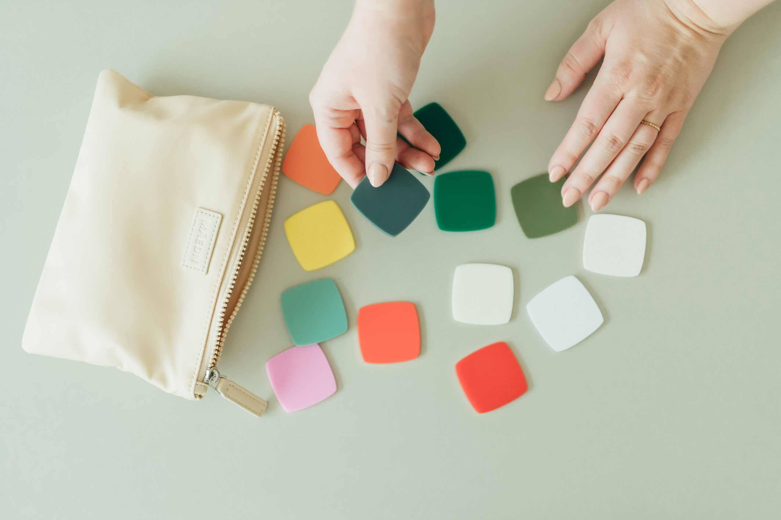 Ashlee Wiggins hands holding acrylic samples at a desk