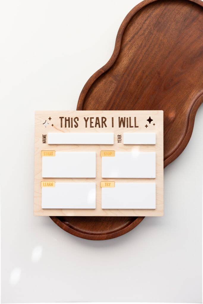 Laser cut wooden New Year's sign for people to list their goals for the New Year on a dry erase board by Made of Embers
