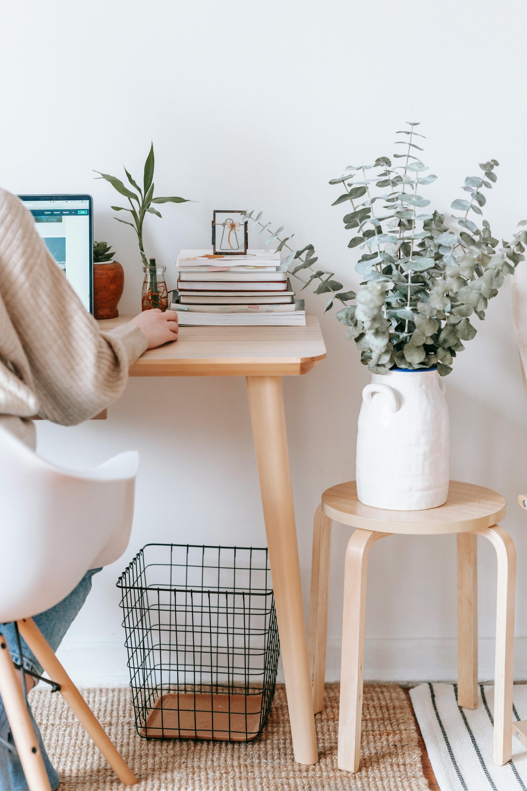 Stock photo of someone sitting at a desk with a laptop and office decor around her